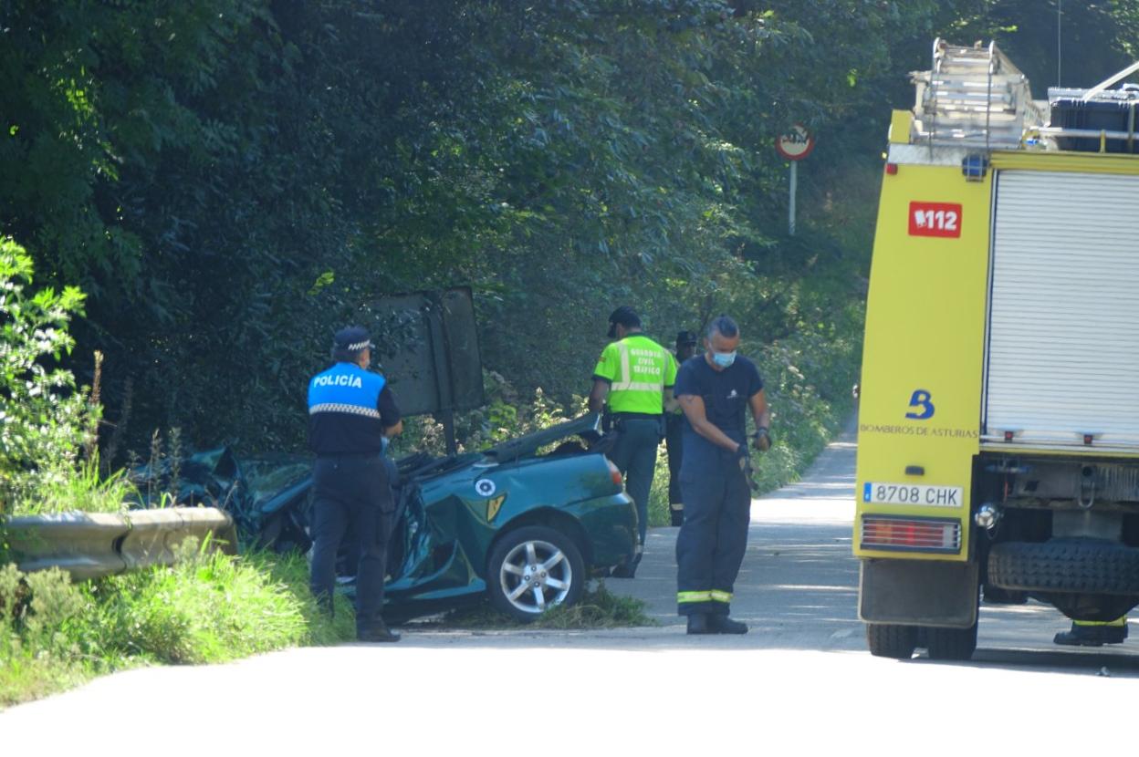 Policía Local, Guardia Civil y bomberos, en el tramo de carretera entre Quintana y Balmori, junto al coche en el que viajaba el fallecido. 