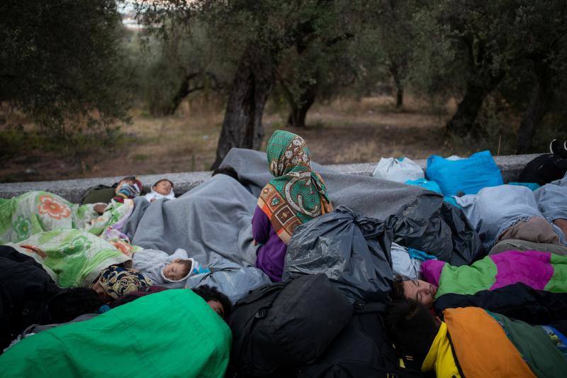 Miles de personas pasan la noche a la intemperie en los alrededores del devastado campo de refugiados de Moria (Lesbos), el más grande de Grecia, a la espera de ser trasladados. Las carreteras que rodean el campo, en el que malvivían 13.000 personas, están repletas de familias que con lo poco que les ha quedado se han instalado en la calzada o en alguna cercana al campo que no ha sido destruida por el incendio del martes por la noche; un incendio que comenzó simultáneamente en varios puntos del campo, poco después de que las autoridades comunicaran a 35 personas que habían dado positivo de covid-19 y que debían ser aisladas. 