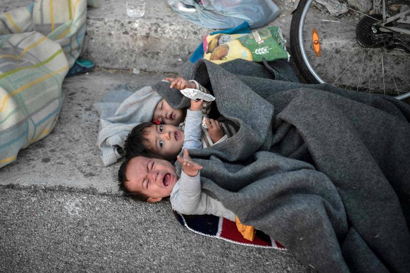 Miles de personas pasan la noche a la intemperie en los alrededores del devastado campo de refugiados de Moria (Lesbos), el más grande de Grecia, a la espera de ser trasladados. Las carreteras que rodean el campo, en el que malvivían 13.000 personas, están repletas de familias que con lo poco que les ha quedado se han instalado en la calzada o en alguna cercana al campo que no ha sido destruida por el incendio del martes por la noche; un incendio que comenzó simultáneamente en varios puntos del campo, poco después de que las autoridades comunicaran a 35 personas que habían dado positivo de covid-19 y que debían ser aisladas. 