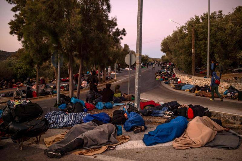 Miles de personas pasan la noche a la intemperie en los alrededores del devastado campo de refugiados de Moria (Lesbos), el más grande de Grecia, a la espera de ser trasladados. Las carreteras que rodean el campo, en el que malvivían 13.000 personas, están repletas de familias que con lo poco que les ha quedado se han instalado en la calzada o en alguna cercana al campo que no ha sido destruida por el incendio del martes por la noche; un incendio que comenzó simultáneamente en varios puntos del campo, poco después de que las autoridades comunicaran a 35 personas que habían dado positivo de covid-19 y que debían ser aisladas. 