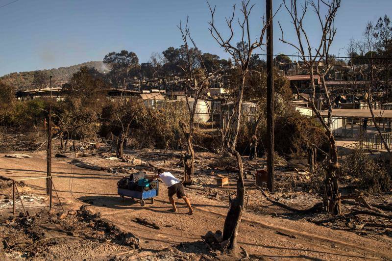 Miles de personas pasan la noche a la intemperie en los alrededores del devastado campo de refugiados de Moria (Lesbos), el más grande de Grecia, a la espera de ser trasladados. Las carreteras que rodean el campo, en el que malvivían 13.000 personas, están repletas de familias que con lo poco que les ha quedado se han instalado en la calzada o en alguna cercana al campo que no ha sido destruida por el incendio del martes por la noche; un incendio que comenzó simultáneamente en varios puntos del campo, poco después de que las autoridades comunicaran a 35 personas que habían dado positivo de covid-19 y que debían ser aisladas. 