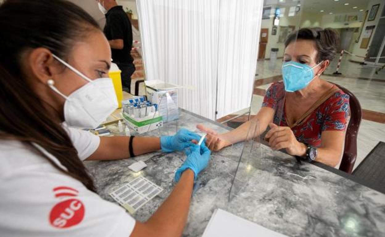 Una enfermera toma una muestra de sangre a una ciudadana para un test serológico 