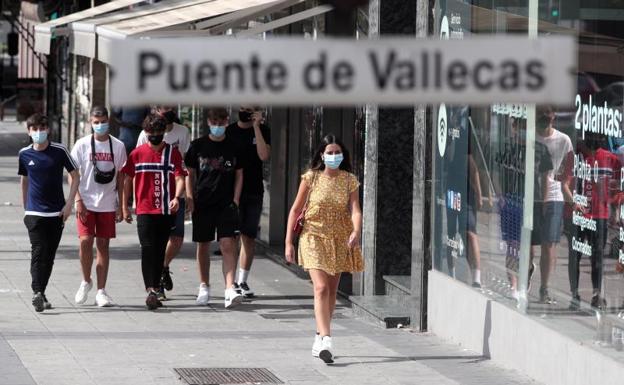 Unos adolescentes caminan por una calle de Puente de Vallecas. 