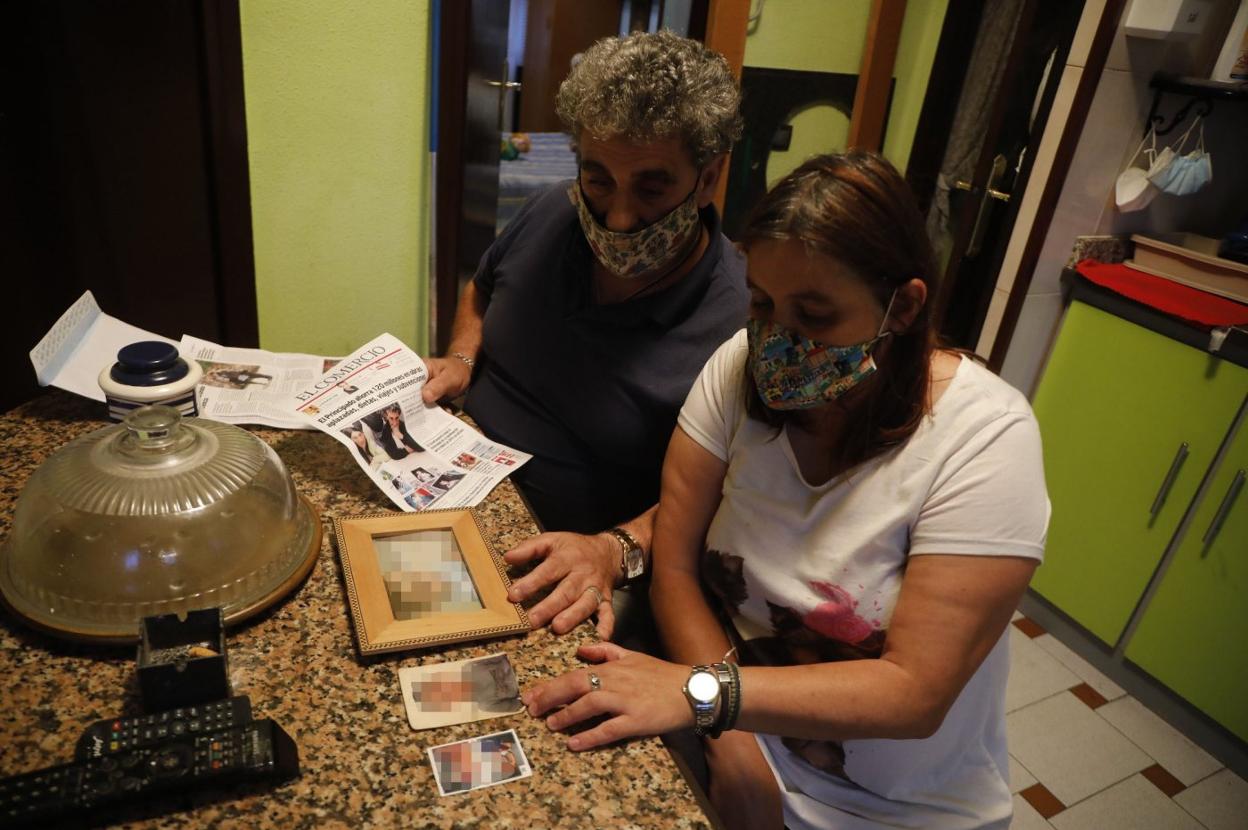 José Antonio y María Elena observan las fotografías de sus hijos en su casa de Barredos. 