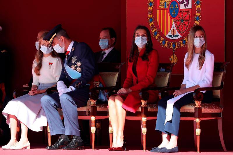 El estilismo de la Reina Letizia, de la Princesa Leonor y de la Infanta Sofía durante el desfile del 12 de octubre en la plaza de la Armería del Palacio Real de Madrid han captado la atención mediática. La Reina ha vuelto a apostar por Felipe Varela y ha rescatado un sobrio dos piezas de inspiración oriental, formado por un vestido de terciopelo con botones y un abrigo recto en crepe que se abrocha con pequeños lazos. La Princesa Leonor ha lucido una falda abullonada de color azul y un cuerpo con mangas de farol, del que prendía la insignia de la orden del Toisón de Oro. La Infanta Sofía, mucho más sobria, ha optado este 12-O por un conjunto compuesto por un pantalón ancho y una camisola con gran lazada.