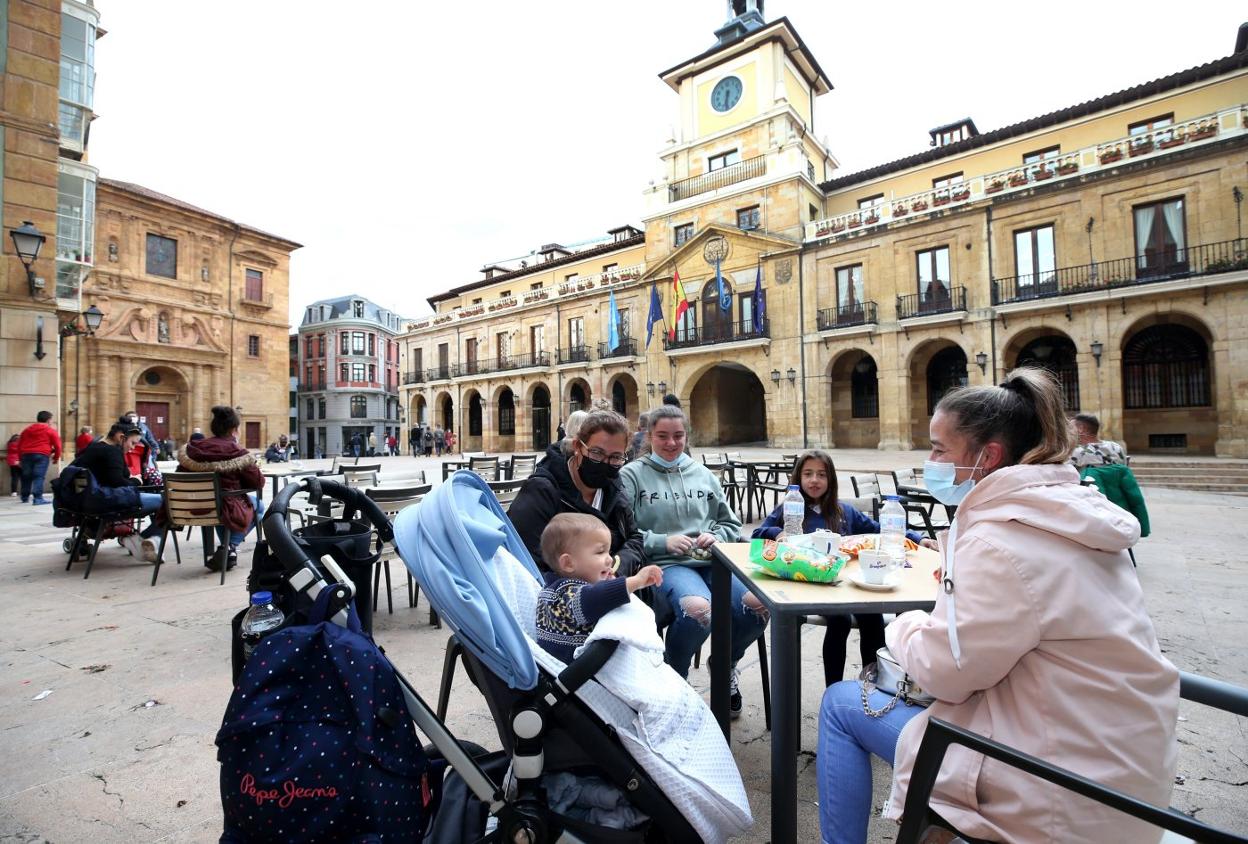 Una familia con niños disfruta de la tarde en una terraza de la plaza de la Constitución. 