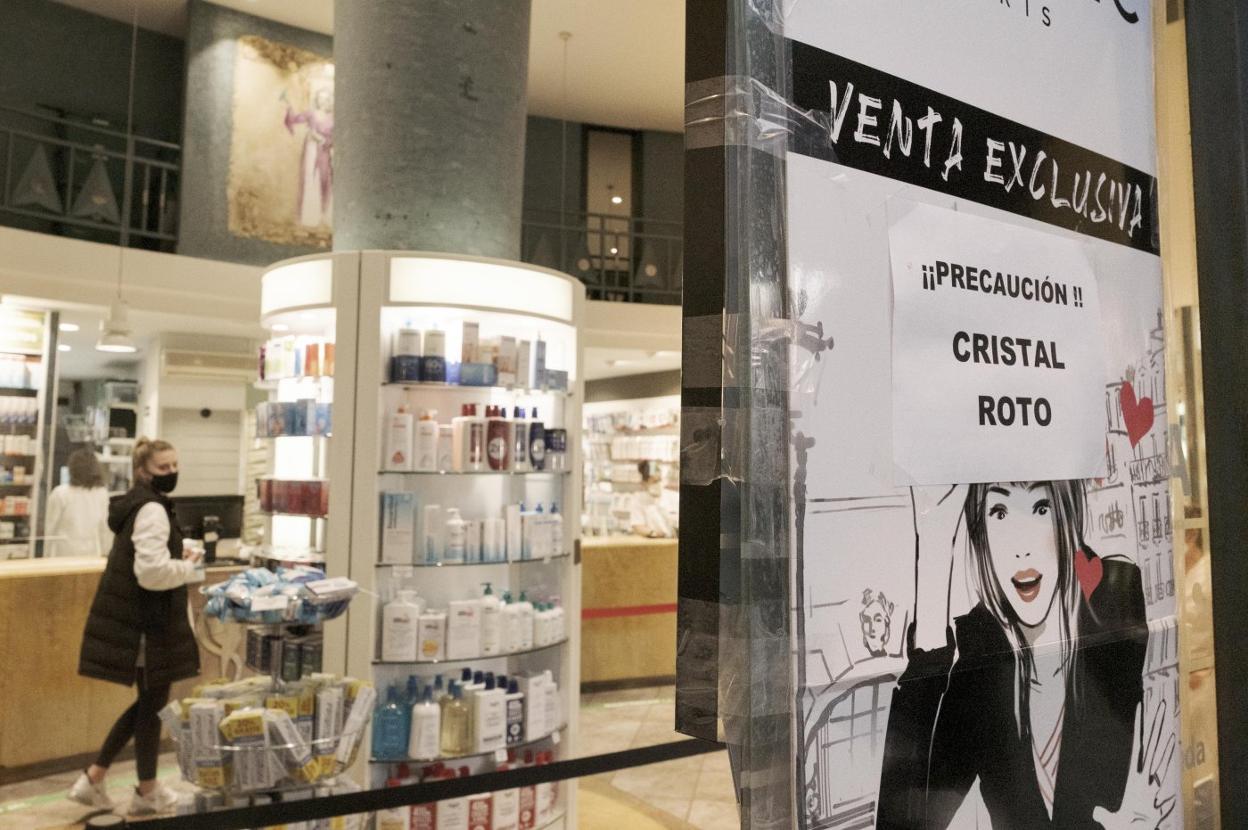 Los daños en la puerta de la farmacia de la avenida de El Llano. 