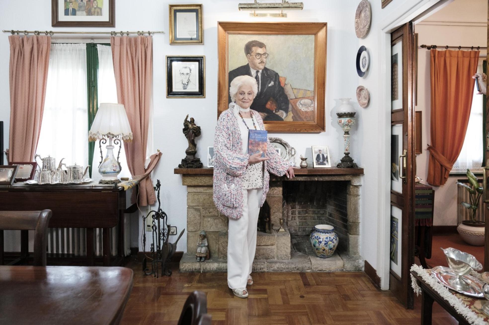 La escritora posa con su novela, 'La Yihad de Almanzor', que acaba de ser publicada, ante el retrato de su marido. 