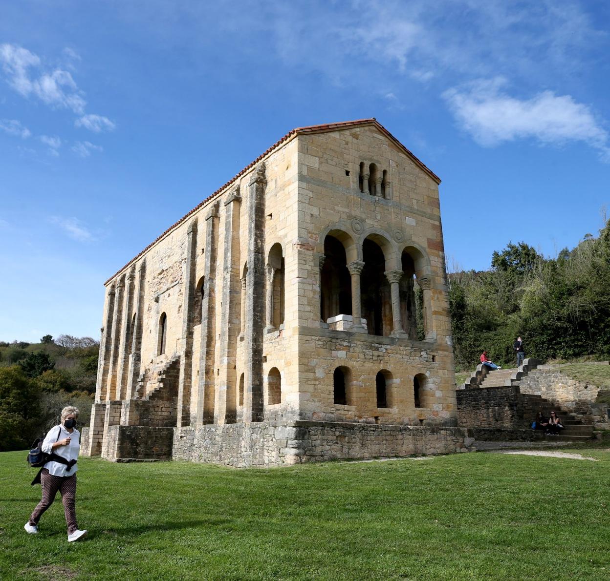 Una mujer camina por delante del monumento de Santa María del Naranco.