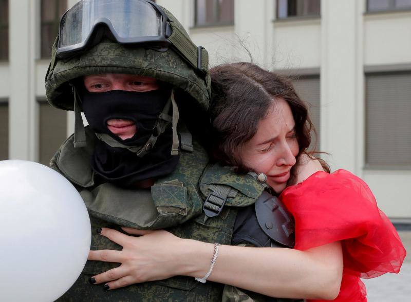 Una mujer abraza a un miembro de las tropas de Bielorrusia mientras hace guardia durante una manifestación para protestar contra la violencia policial y rechazar los resultados de las elecciones presidenciales cerca de la Casa de Gobierno en la Plaza de la Independencia en Minsk, Bielorrusia, el 14 de agosto de 2020. 