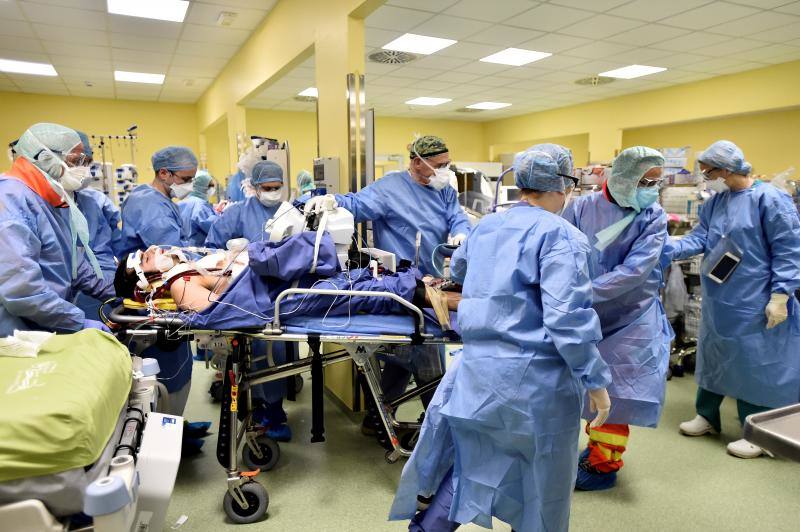 Varios miembros del personal médico,equipados con trajes protectores, trasladan a un paciente de 18 años que padece covid-19 a una unidad de cuidados intensivos en el hospital San Raffaele en Milán, Italia, el 27 de marzo de 2020. 