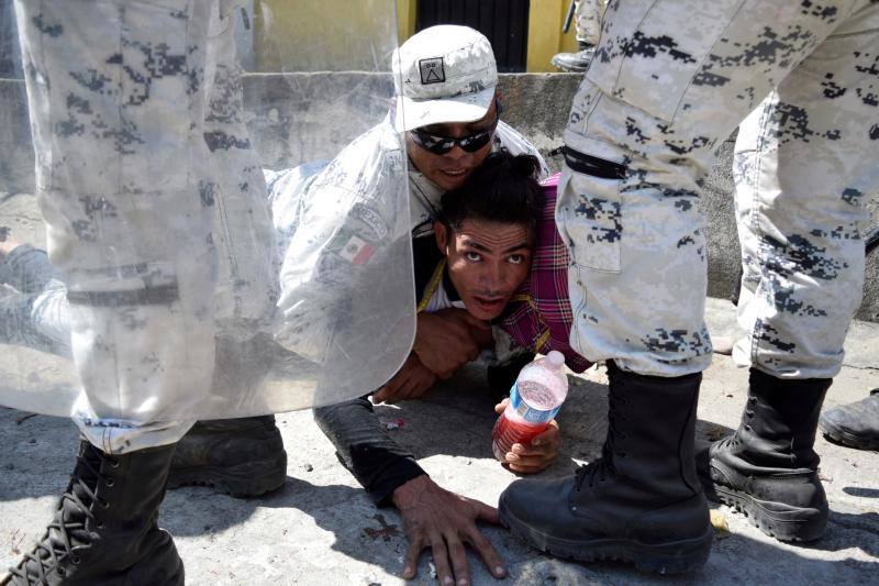 Un miembro de la Guardia Nacional de México detiene a un migrante que viaja a EE UU. Cerca de la frontera entre Guatemala y México, en Ciudad Hidalgo, México, 20 de enero de 2020. 