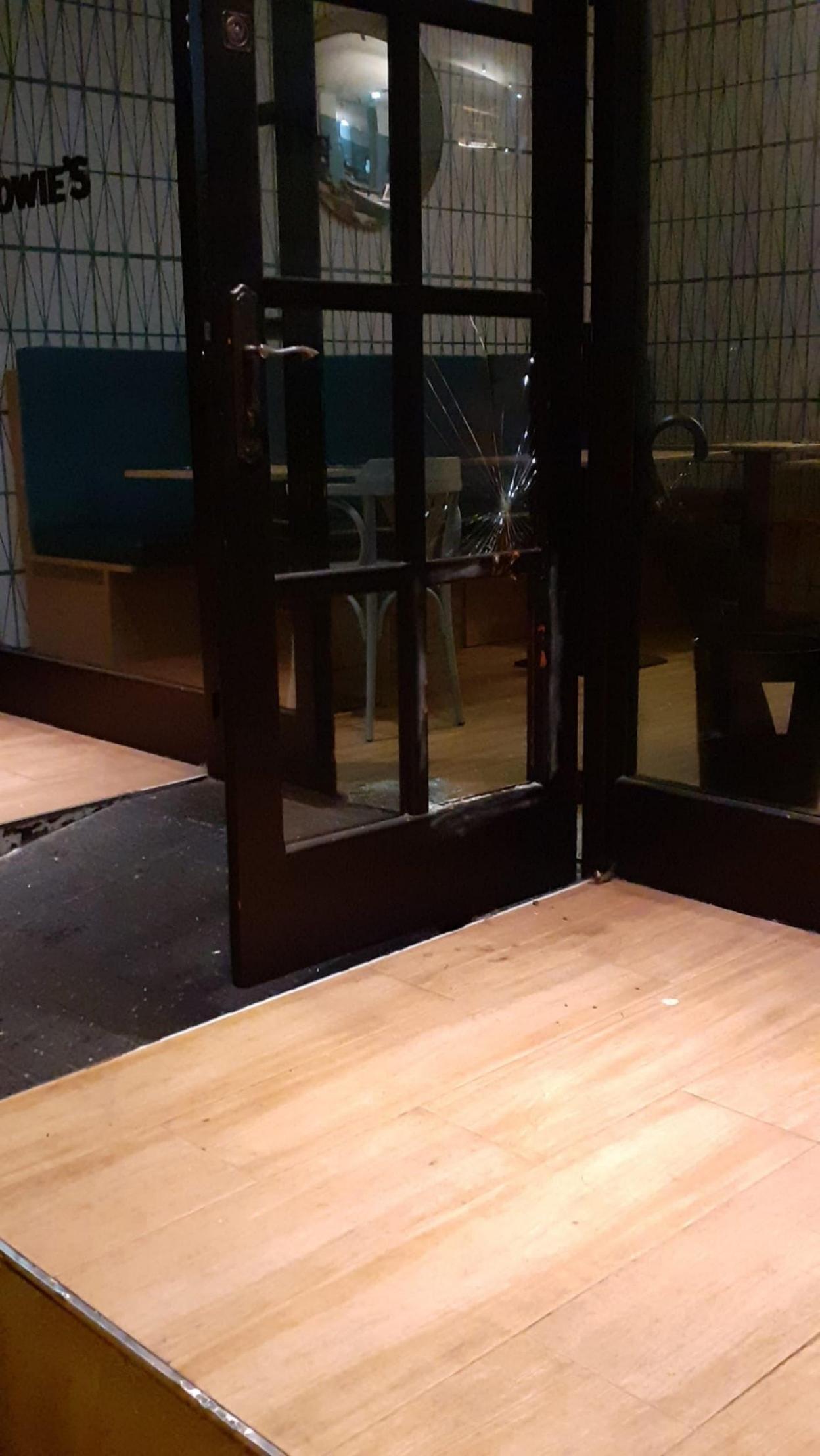 Estado en el que quedó la puerta de la hamburguesería tras cometerse el robo. 