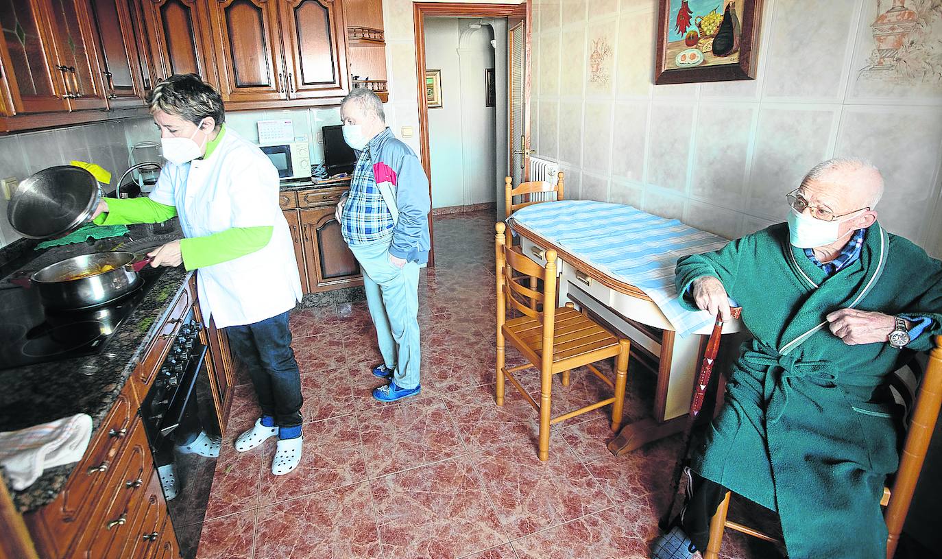 Lucía Francés prepara la comida en presencia de Jaime, de 92 años, y su hijo Carlos, de 54, con síndrome de Down, en Las Vegas, Corvera. 