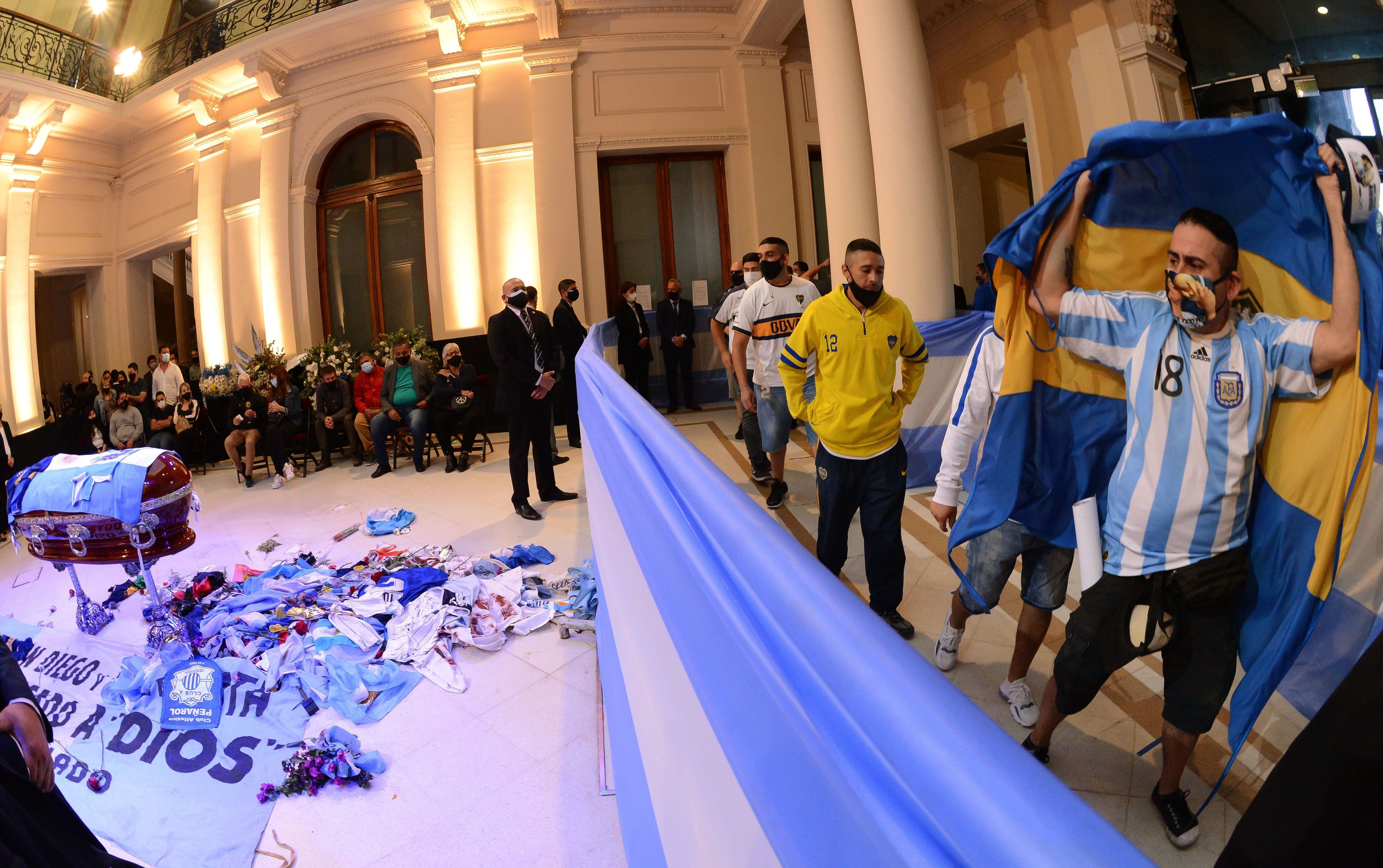 Aficionados se emocionan ante el féretro de Diego Armando Maradona. 