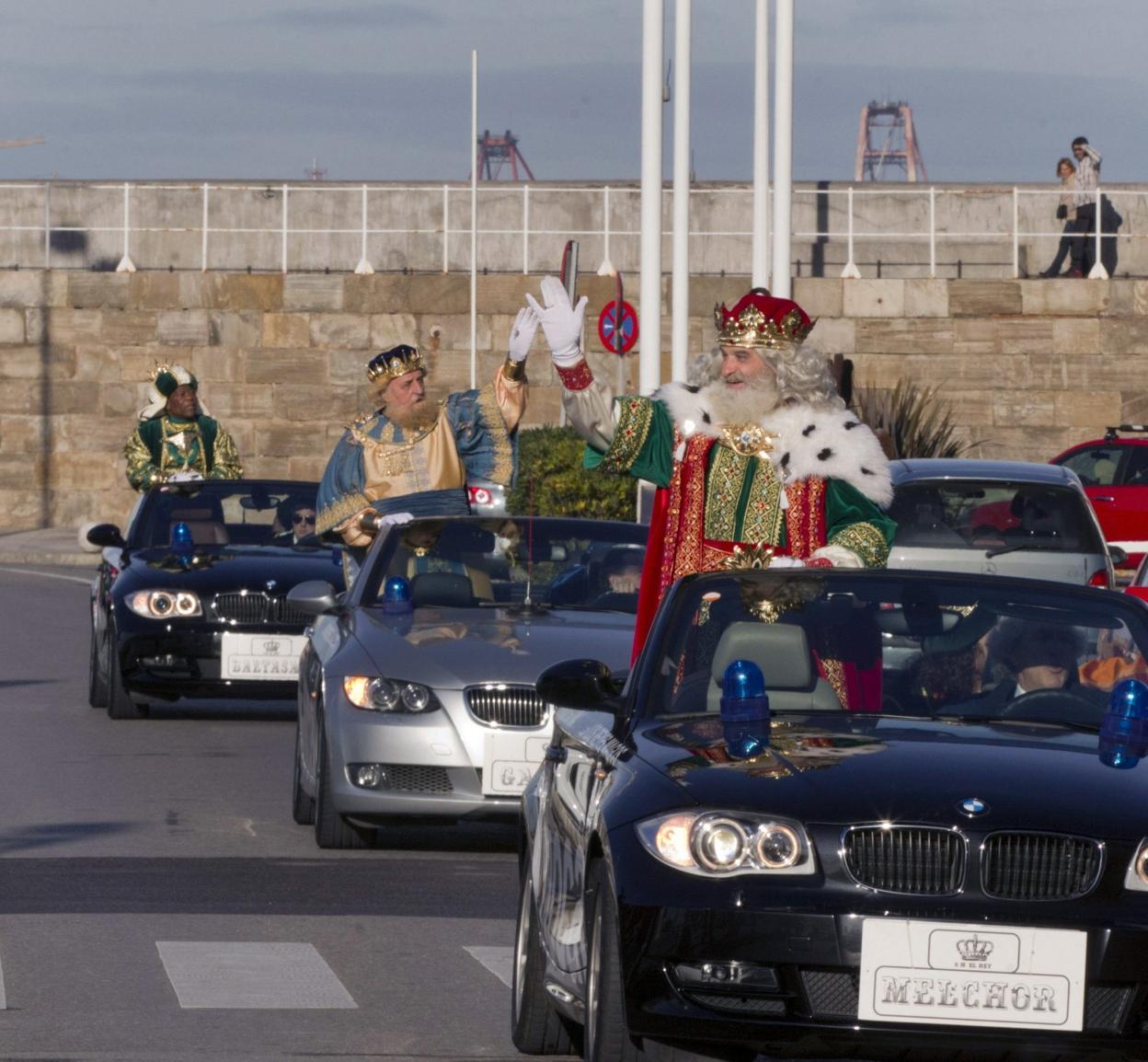 Melchor, Gaspar y Baltasar, en vehículos descapotables, en uno de sus desplazamientos por la ciudad. 