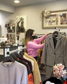 Imagen secundaria 2 - Covadonga Tuya perfilando prendas en la tienda 'Bonaire', que lleva junto a su madre en Gijón. 