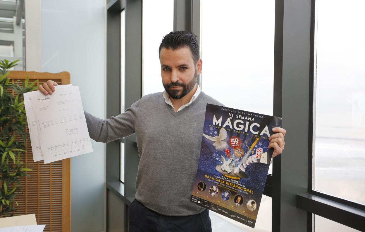 José Armas enseña una factura y un cartel del Festival de Magia. 
