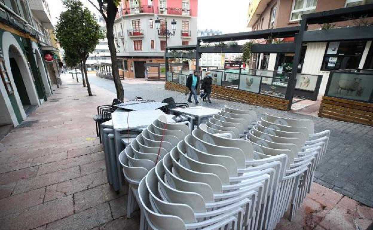 Las sillas y mesas de una terraza de Oviedo recogidas.
