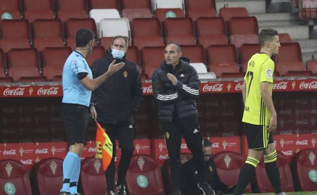 Iván Martínez, sin mascarilla, se dirige al árbitro en el partido de este domingo en El Molinón. 