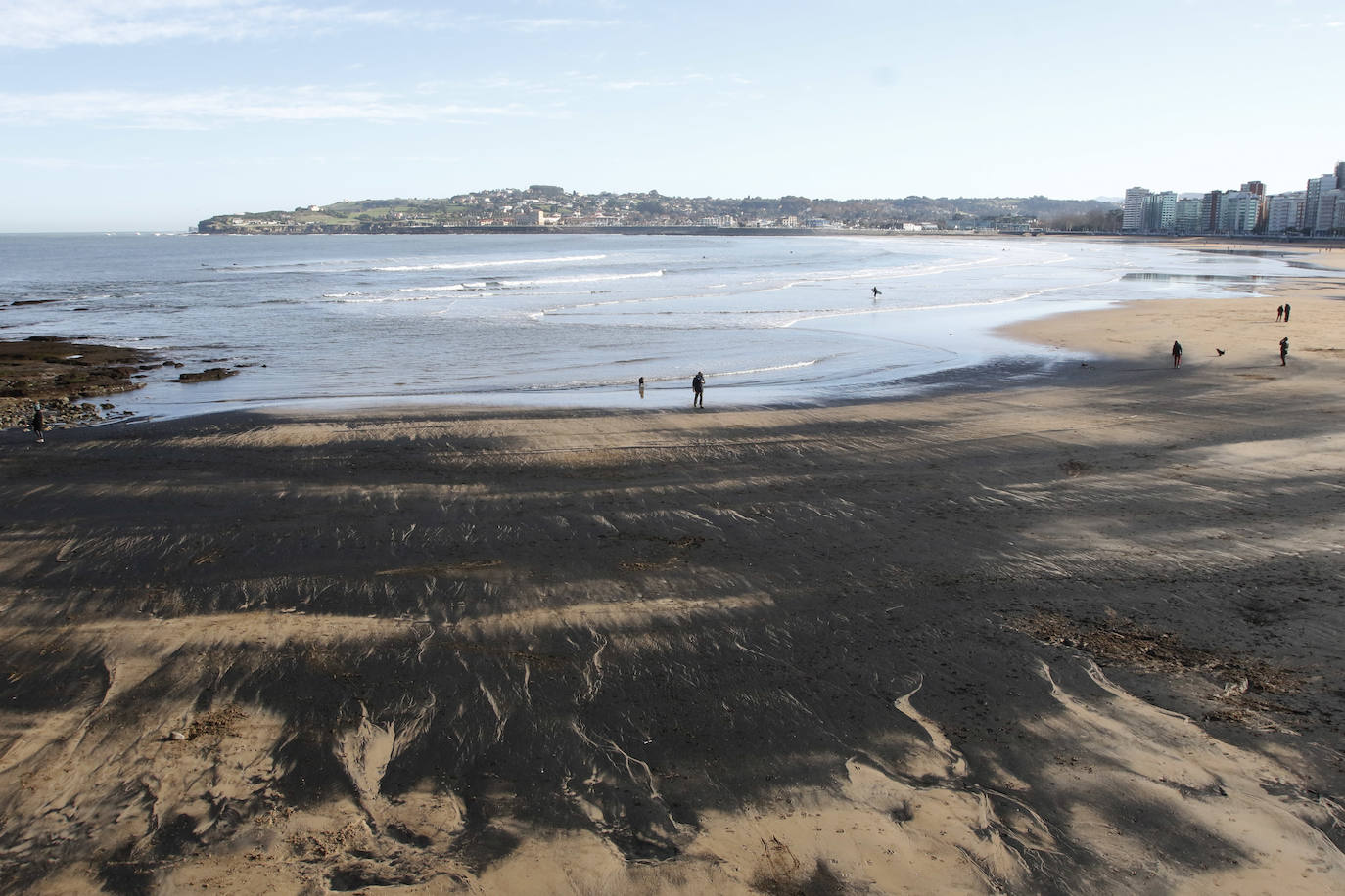 La playa de San Lorenzo de Gijón ha amanecido cubierta de carbón este jueves, casualmente coincidiendo con el día en el que se presentaban las conclusiones del estudio del laboratorio de Petrografía del Incar. Esta investigación atribuye a El Musel las manchas en el arenal gijonés. Apunta a la carga y descarga de carbón en los muelles y descarta que el material llegue por el viento. 