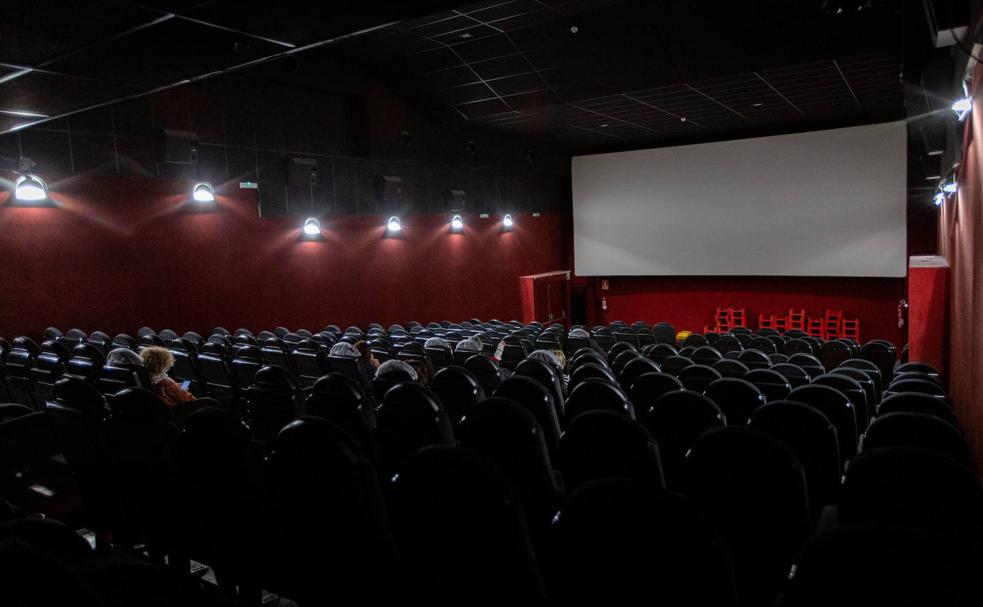 Varios espectadores esperan a que empiece la película, en una sala de cine de Vitoria.