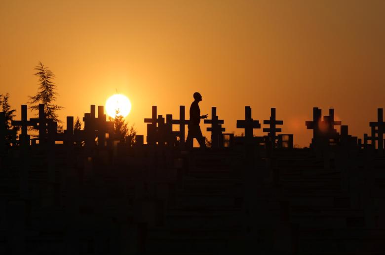 Chipre | La silueta de un hombre contra la puesta de sol mientras pasa junto a las tumbas de los soldados muertos en la invasión turca de Chipre en 1974 en el cementerio militar Tymvos Macedonitissas en Nicosia