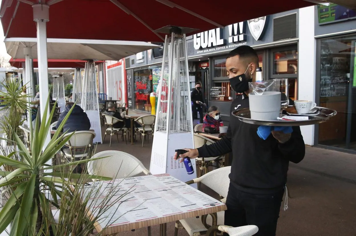 Un camarero desinfecta una de las mesas de una terraza situada en El Molinón. 