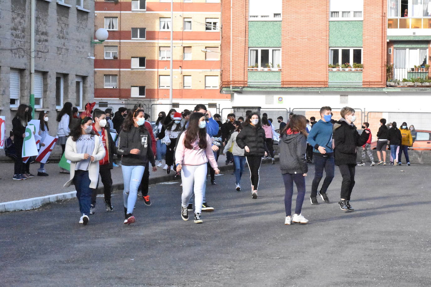 Son sus vecinos. Frente a frente instituto y residencia. Tan juntos pero a tanta distancia. Y en una situación tan especial y tan dura como esta pandemia. Por eso los estudiantes del IES Montevil de Gijón decidieron salir este miércoles delante del instituto para transmitirles ánimos y desearles unas felices fiestas a los mayores que cada día les ven entrar y salir con sus mochilas. Con bailes, con pancartas y con saludos les hicieron ver que no están solos y que los abuelos son muy especiales.