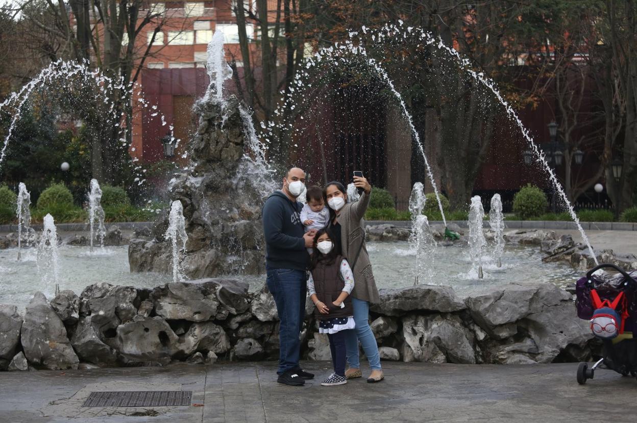 Adrián Mendoza y su familia se retratan frente a la Fuente de las Ranas del Campo de San Francisco, que vuelve a tener agua desde este jueves. 