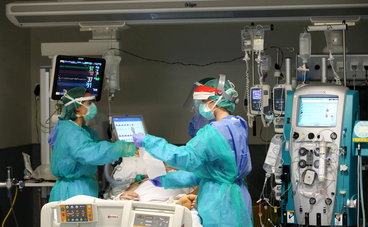 Sanitarios asisten a un paciente en la UCI del HUCA.