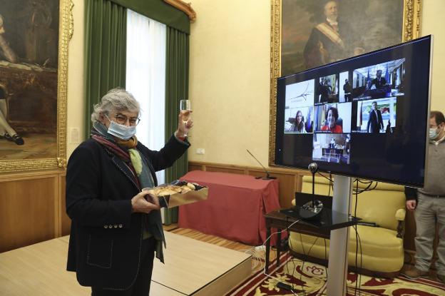 Ana González levanta la copa para brindar de forma telemática con el resto de alcaldes. En la mano, los dulces enviados por Avilés. 