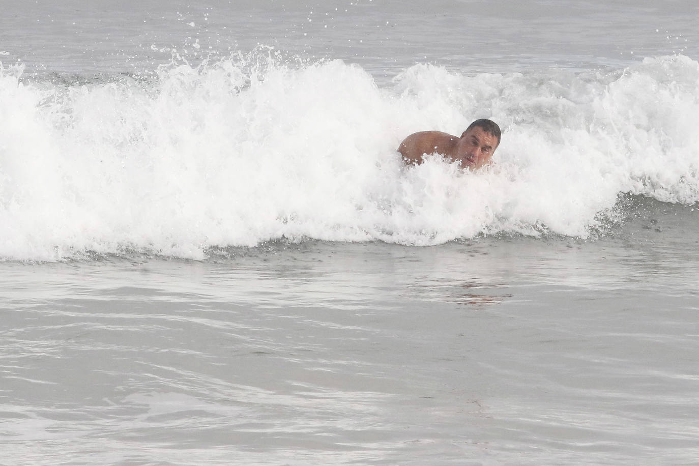 El frío no ha podido con los valientes que han decidido darse un chapuzón en la playa de San Lorenzo, de Gijón, durante este frío día de Reyes. En la mañana de este miércoles las temperaturas máximas apenas han superado los 8 grados. 