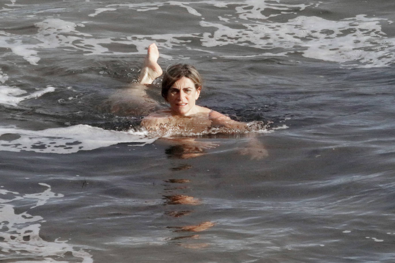 El frío no ha podido con los valientes que han decidido darse un chapuzón en la playa de San Lorenzo, de Gijón, durante este frío día de Reyes. En la mañana de este miércoles las temperaturas máximas apenas han superado los 8 grados. 