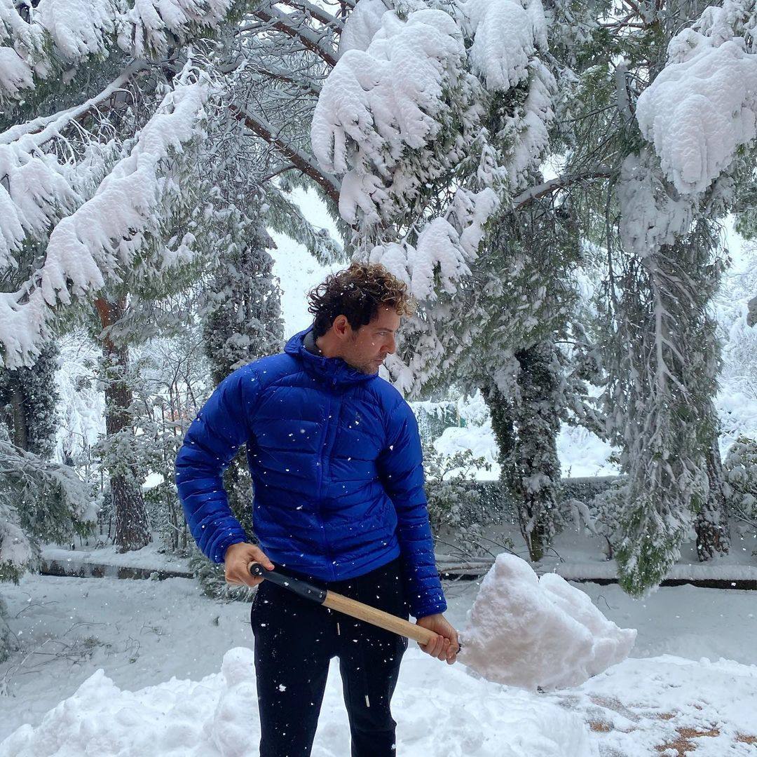 David Bisbal trata de recoger un poco de nieve.