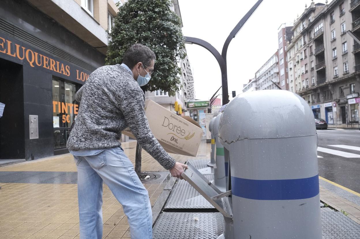Un ciudadano utiliza un contenedor de reciclaje. 