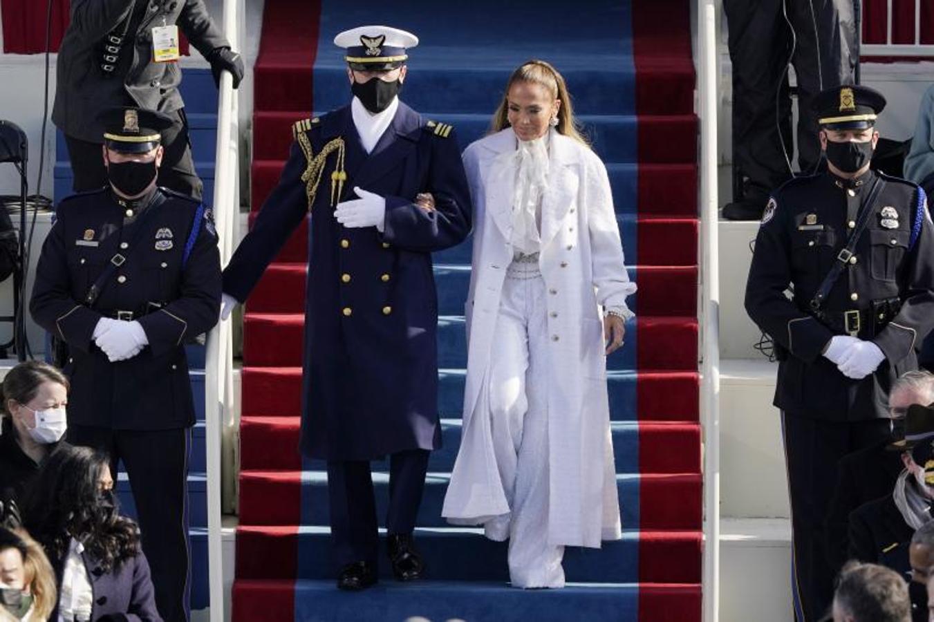 Un marine escolta a Jennifer Lopez antes de cantar en la toma de posesión de Biden. 