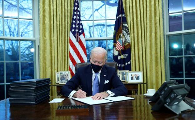 El presidente de EE UU, Joe Biden, firma los decretos.