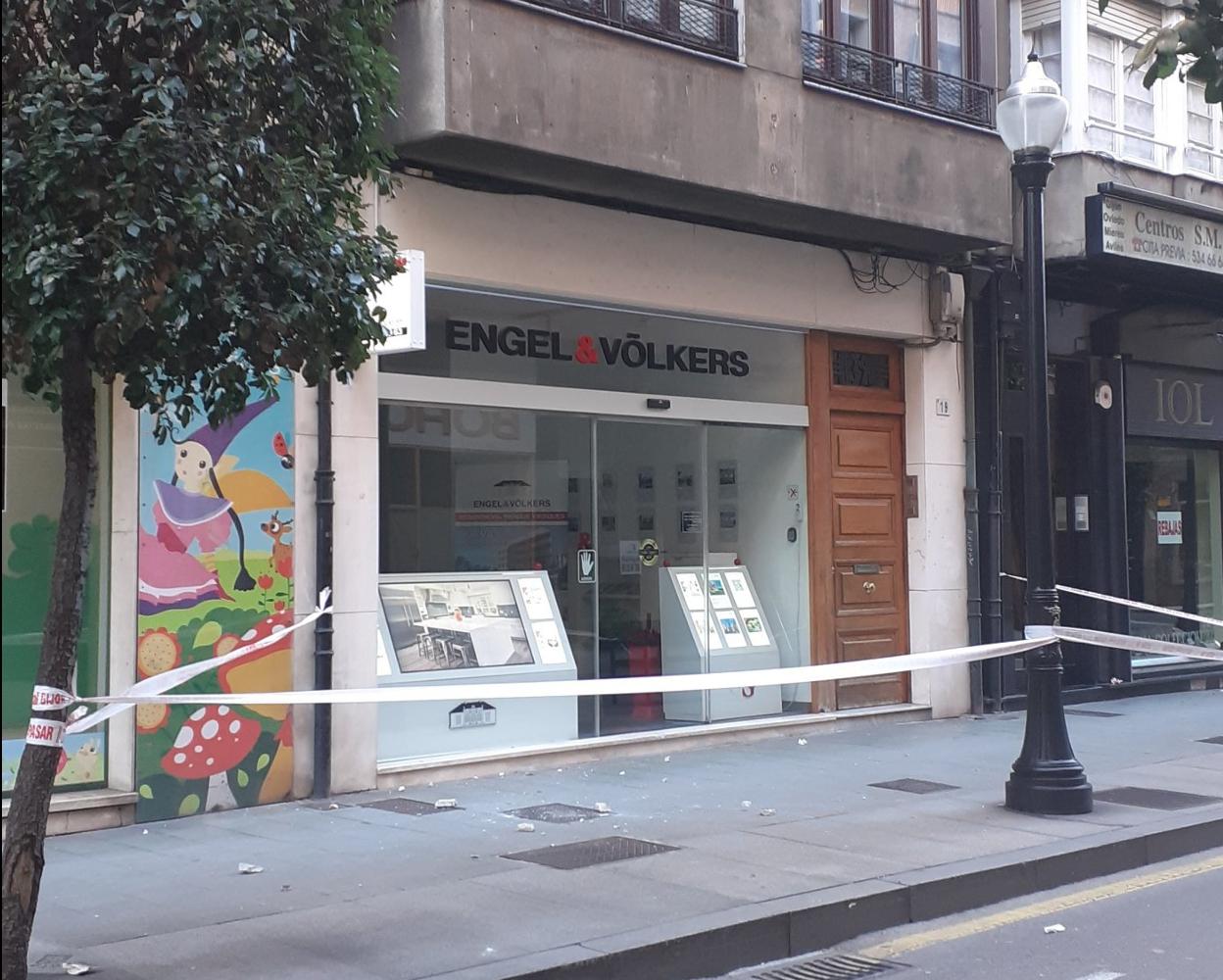 Arriba los cascotes que se desprendieron del edifiico de la calle Menéndez Valdés. A la derecha, la Policía Local en la calle tras acordonar la zona, a la espera de los bomberos para sanear la fachada. 