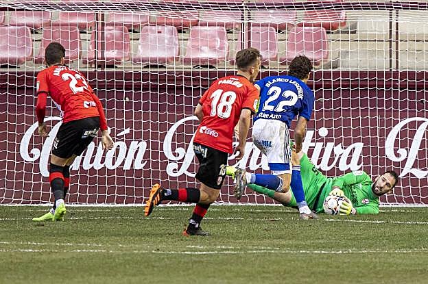 Dani Giménez detiene una ocasión del Oviedo con Blanco Leschuk, atento al rechace. 