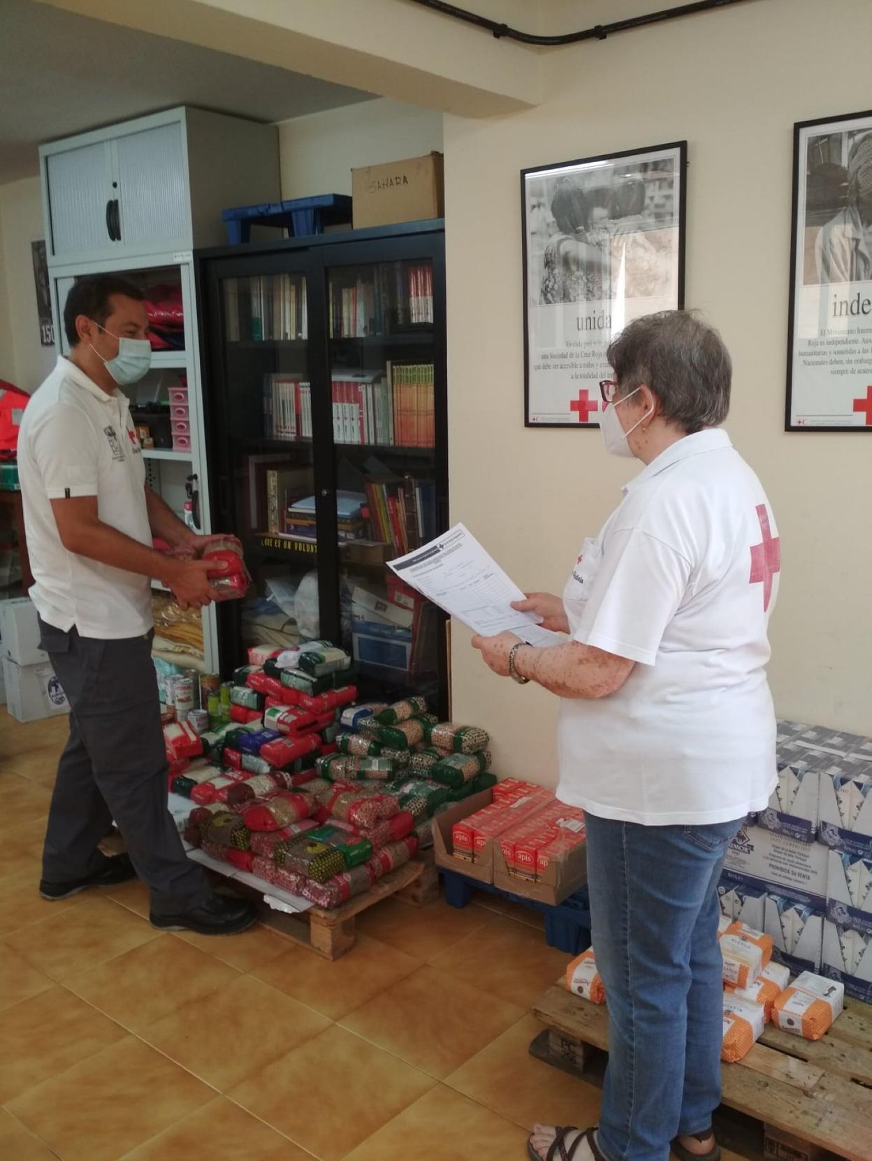 Dos voluntarios preparan la comida para su reparto. 