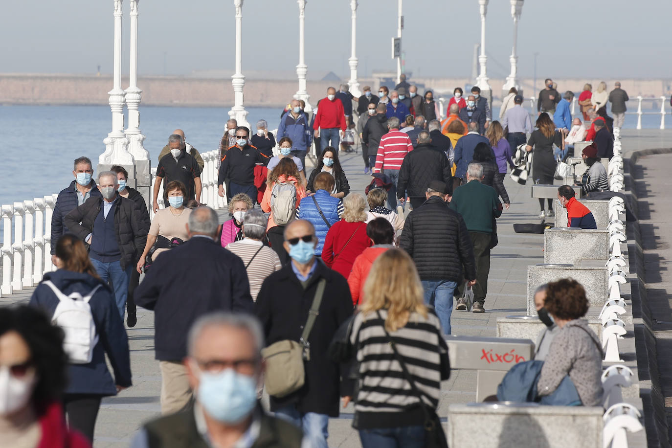 Las agradables temperaturas de este jueves y el sol permitieron que muchos gijoneses optasen por disfrutar de El Muro y de la playa en pleno mes de enero.