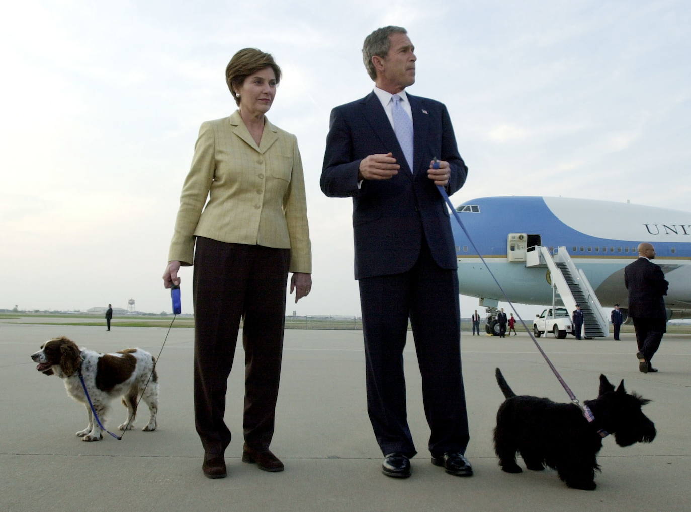 George W. Bush,presidente estadounidense, y su esposa Laura, en compañía de sus dos perros, Barney (d) y Spot (i), en el aeropuerto de Waco (Texas)