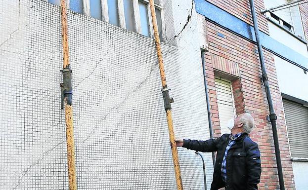 Domingo González frente un muro apuntalado en la barriada.