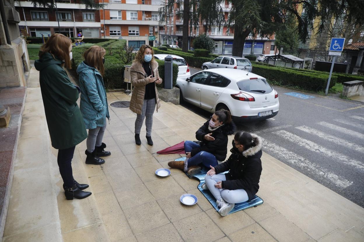 Dos hosteleras de Lena, delante de su Consistorio siendo atendidas por la alcaldesa y otros miembros de la Corporación. 