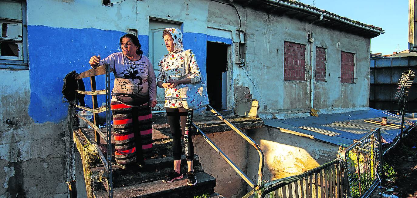 Ludivina Jiménez y Mari Carmen García, en las escaleras de acceso al 168 de La Tenderina, a su izquierda la pasarela que hay que recorrer para poder entrar en la vivienda y desde el que cayó J. R. P, sufriendo un golpe que le provocó la muerte pocas horas después. 