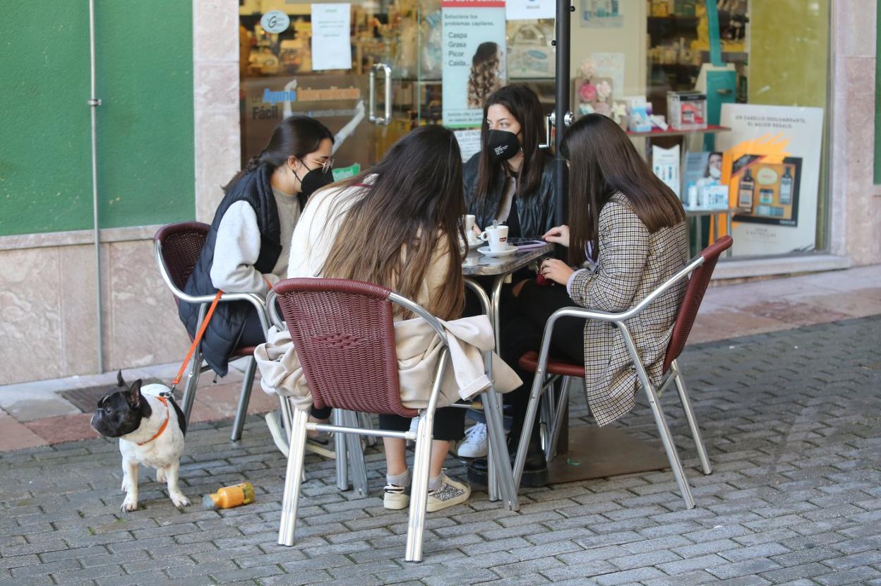 Varias jóvenes disfrutan de una terraza en Grado. 