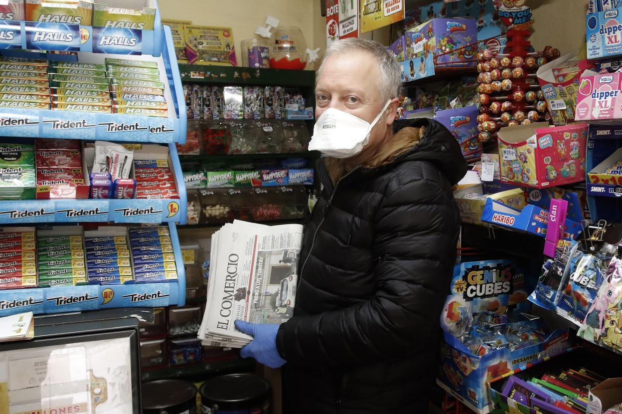 Un quiosquero, con numerosos ejemplares de EL COMERCIO a la venta. 