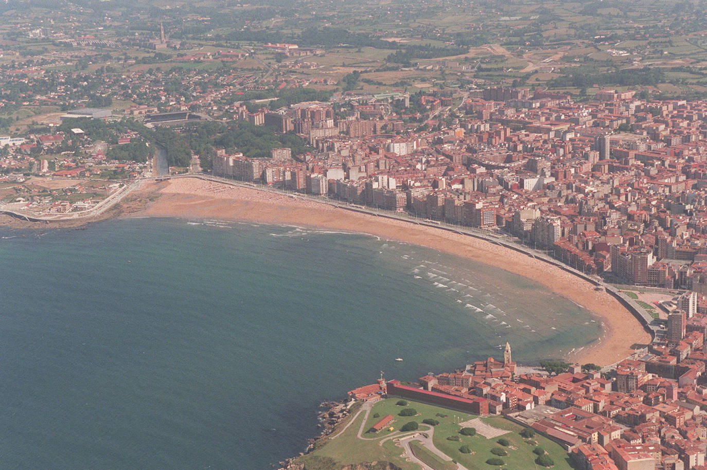 Un paseo por la historia gráfica de la playa de San Lorenzo que arranca con una reproducción de 1900 permite comprobar si el paso de los años han cambiado la orografía y el aspecto del arenal después de que el Ministerio de Transición Ecológica y el Reto Demográfico augurara en un informe que Gijón sufrirá daños anuales de 10 millones por la subida del mar debido al cambio climático