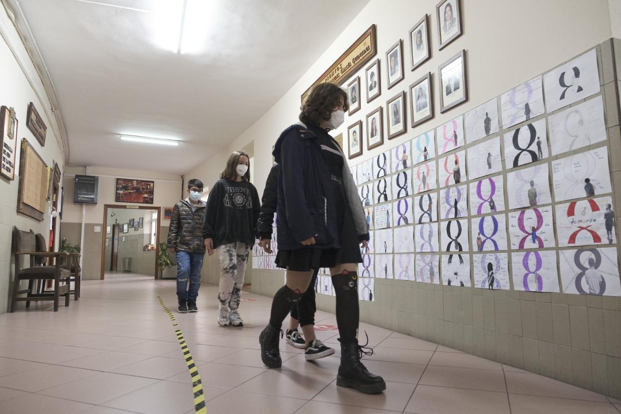Varias jóvenes pasan por la exposición. 